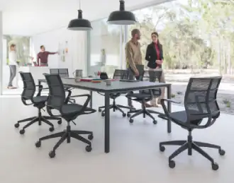 Temptation 4 bench desk being used for team meetings, shown in a black finish