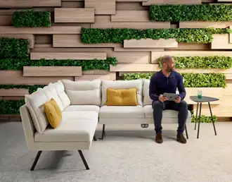 White upholstered L-shaped sofa with wood legs and integrated charging